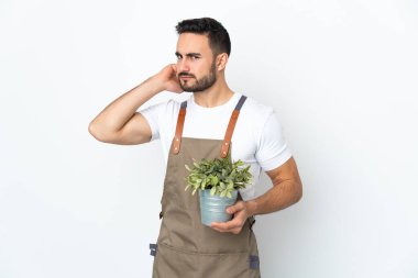 Bahçıvan beyaz arka planda bir bitki tutuyor. Şüpheleri var.