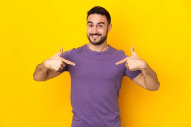 Sarı arka planda soyutlanmış, gururlu ve kendini beğenmiş beyaz yakışıklı bir adam.