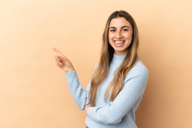 Beyazlı genç bir kadın bej arka planda izole edilmiş.