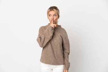 Beyaz arka planda izole edilmiş genç bir Rus kadın sessizlik işareti gösteriyor. Parmağını ağzına sokuyor.