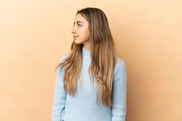 Young Caucasian Woman Isolated Beige Background Looking Side — Stock Photo, Image