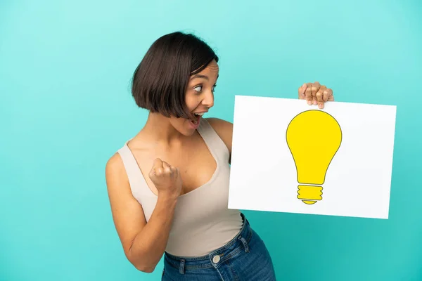 Young Mixed Race Woman Isolated Blue Background Holding Placard Bulb — Stock Photo, Image