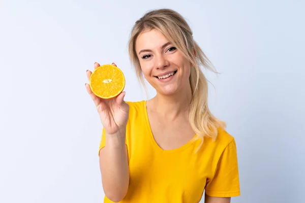 Blond Kvinna Över Isolerad Blå Bakgrund Håller Orange — Stockfoto