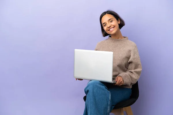 Jovem Mestiça Sentada Uma Cadeira Com Laptop Isolado Fundo Roxo — Fotografia de Stock