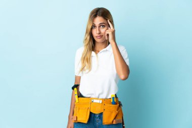 Genç sarışın Uruguaylı elektrikçi kadın mavi arka planda izole edilmiş bir fikir düşünüyor.