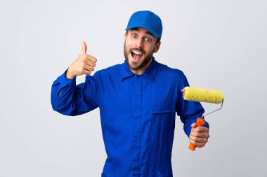 Boyacı beyaz arka planda izole edilmiş bir boya silindiri tutuyor.