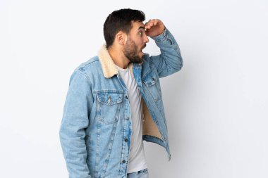 Beyaz arka planda sakallı, yakışıklı genç bir adam.