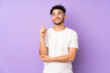 Münzevi bir geçmişi olan yakışıklı Arap bir adam harika bir fikre işaret ediyor.