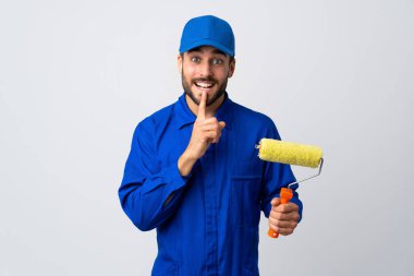 Beyaz arka planda izole edilmiş bir boya silindiri tutan ressam parmağını ağzına koyan sessizlik işareti gösteriyor.