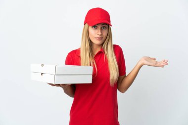 Pizza dağıtan kadın beyaz arka planda izole edilmiş bir pizza tutuyor. Şüpheleri var ve ellerini kaldırıyor.