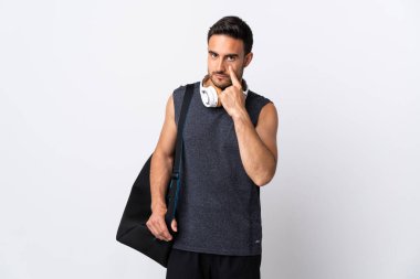 Spor çantalı genç adam beyaz arka planda izole edilmiş bir şey gösteriyor.