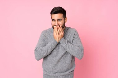 Kafkas yakışıklı adam izole edilmiş arka planda mutlu ve gülümsüyor elleriyle ağzını kapatıyor.