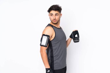 Beyaz arka planda izole edilmiş Arap spor adamı halter olarak ağırlık kaldırıyor.