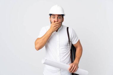 Miğferli ve elinde planları olan genç bir mimar beyaz arka planda izole edilmiş ağzı elleriyle kapatıyor.