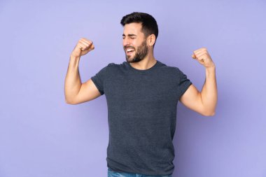 Kafkasyalı yakışıklı adam, izole edilmiş mor arka planda güçlü bir hareket yapıyor.