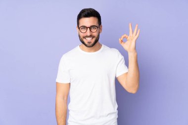 Kafkas yakışıklı adam izole edilmiş arka planda parmaklarıyla tamam işareti gösteriyor.