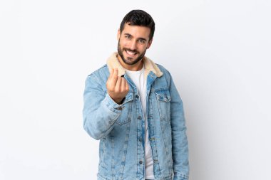 Beyaz arka planda sakallı yakışıklı genç adam para hareketi yapıyor.