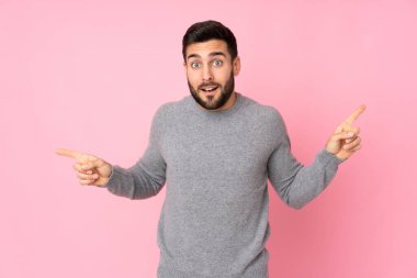 Kafkasyalı yakışıklı adam izole edilmiş arka planda parmak ucunda ve mutlu.