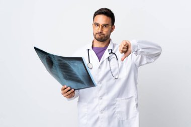 Genç bir doktor elinde beyaz arka planda izole edilmiş bir radyografi tutuyor.