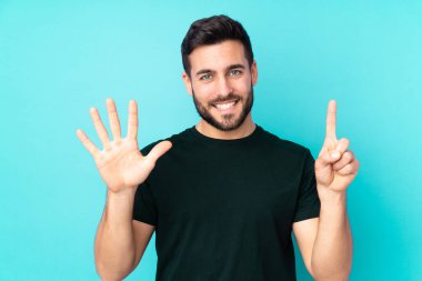 Beyaz tenli yakışıklı adam mavi arka planda izole edilmiş. Parmakları olan altı kişi saydım.