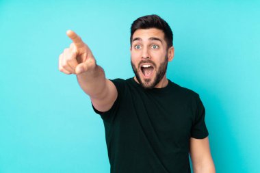 Kafkasyalı yakışıklı adam mavi arka planda izole edilmiş.