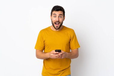 Beyaz arka planda sakallı yakışıklı genç adam şaşırdı ve bir mesaj gönderiyor.