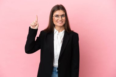 Genç beyaz kadın pembe arka planda izole edilmiş. Harika bir fikre işaret ediyor.