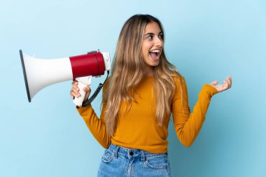 Soyutlanmış mavi arka planda genç İspanyol kadın elinde bir megafon ve şaşırtıcı bir yüz ifadesiyle