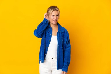 Sarı arka planda izole edilmiş genç bir Rus kadının şüpheleri var.