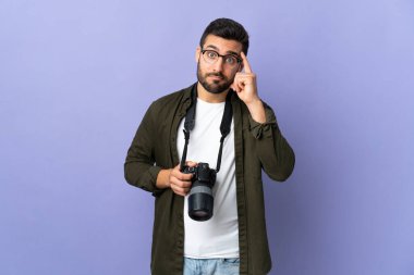 İzole edilmiş mor arka planı olan fotoğrafçı bir fikir düşünüyor.