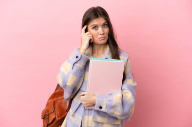 Pembe arka planda izole edilmiş genç bayan bir fikir düşünüyor.