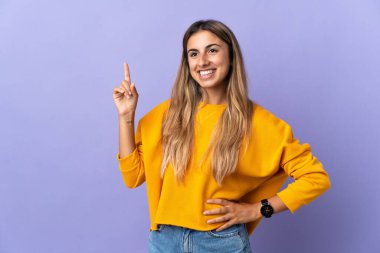 Tecrit edilmiş mor arka planda genç bir İspanyol kadın harika bir fikre işaret ediyor.