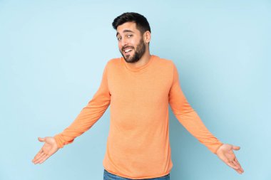 Kafkas yakışıklı adam mutlu ve mavi arka planda gülümsüyor.