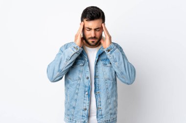 Beyaz arka planda sakallı, yakışıklı ve baş ağrısı olan genç bir adam.