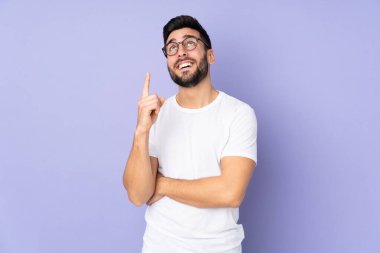 Kafkasyalı yakışıklı adam izole edilmiş arka planda harika bir fikre işaret ediyor.