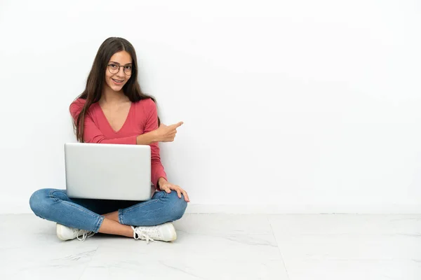 年轻的法国姑娘坐在地板上 笔记本电脑指向后 — 图库照片