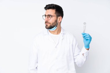 Beyaz arka planda izole edilmiş araçları tutan dişçi