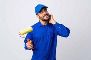 Boyacı beyaz arka planda izole edilmiş bir boya silindiri tutuyor.