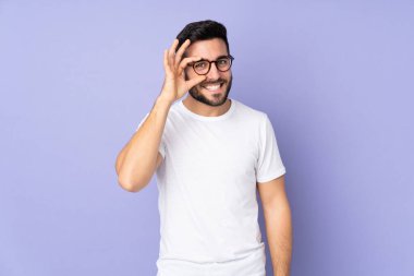 Kafkas yakışıklı adam izole edilmiş arka planda parmaklarıyla tamam işareti gösteriyor.