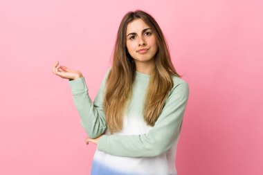 Soyutlanmış pembe arka planı olan genç bir kadın.