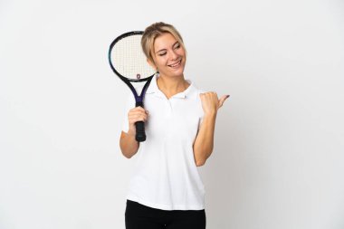 Beyaz arka planda izole edilmiş genç Rus bayan tenisçi bir ürün sunmak için kenarı işaret ediyor