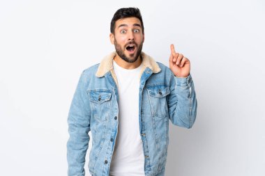 Beyaz arka planda sakallı yakışıklı genç adam bir fikir düşünüyor.