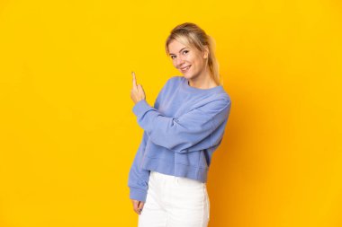 Sarı arka planda izole edilmiş genç bir Rus kadın.