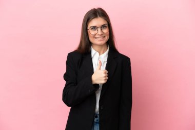 Pembe arka planda izole edilmiş genç beyaz kadın iyi niyet gösterisi yapıyor.