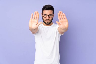 Kafkasyalı yakışıklı bir adam izole edilmiş arka planda durup jest yapıyor ve hayal kırıklığına uğruyor.