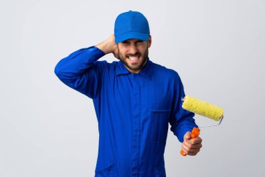 Beyaz arka planda izole edilmiş bir boya silindiri tutan ressam hayal kırıklığına uğramış ve kulaklarını kapatmış.