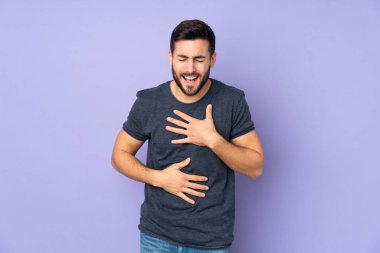 İzole edilmiş mor arka planda gülümseyen beyaz, yakışıklı bir adam.