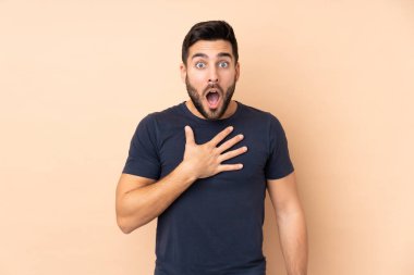 Beyaz tenli yakışıklı adam bej arka planda izole edilmiş.