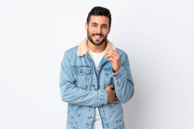 Beyaz arka planda sakallı yakışıklı genç adam gülüyor.