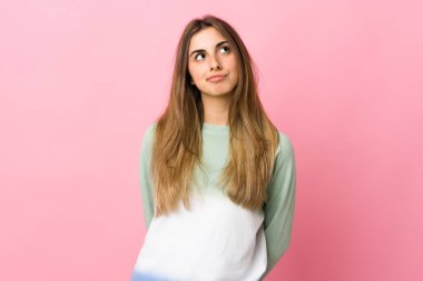 Soyutlanmış pembe arka planı olan genç bir kadın.